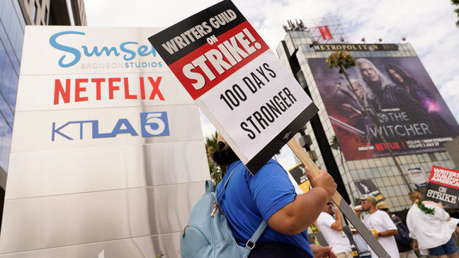 FILE - A picketer carries a sign outside Netflix studios on Wednesday, Aug. 9, 2023, in Los Angeles. (AP Photo/Chris Pizzello)