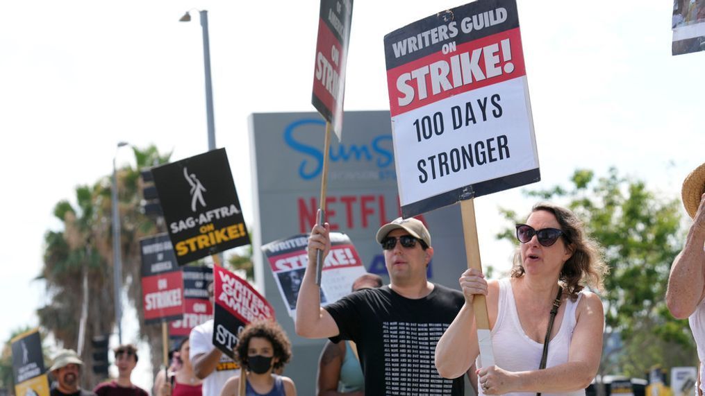 FILE - WGA member Emiliana Dore carries a sign on a picket line outside Netflix studios on Wednesday, Aug. 9, 2023, in Los Angeles. (AP Photo/Chris Pizzello)