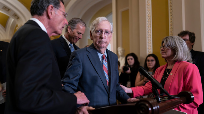 Senate Minority Leader Mitch McConnell, R-Ky., center, is helped by, from left, Sen. John Barrasso, R-Wyo., Sen. John Thune, R-S.D., and Sen. Joni Ernst, R-Iowa, after the 81-year-old GOP leader froze at the microphones as he arrived for a news conference, at the Capitol in Washington, Wednesday, July 26, 2023. (AP Photo/J. Scott Applewhite)